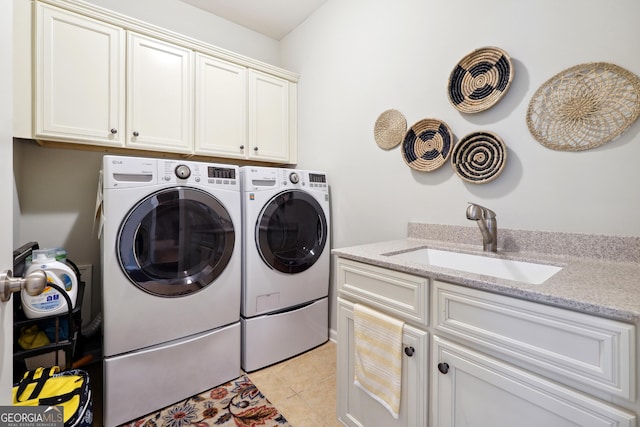 washroom with sink, cabinets, washing machine and clothes dryer, and light tile patterned flooring