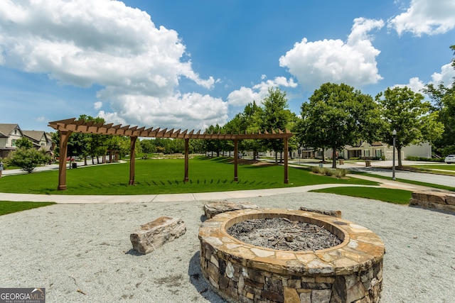 view of community with a pergola, a lawn, and a fire pit