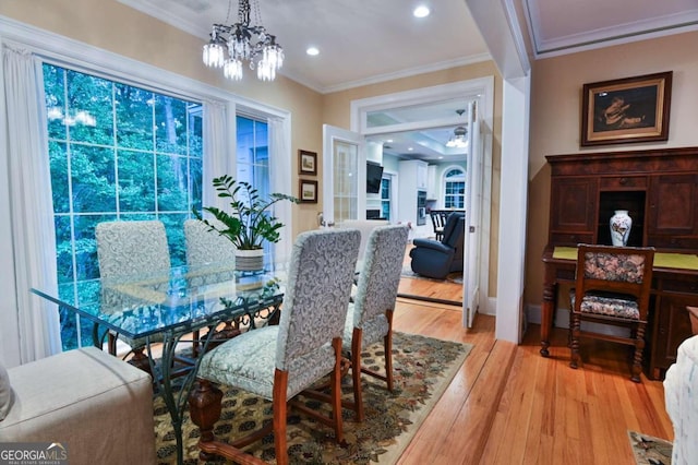 dining room featuring crown molding, light hardwood / wood-style flooring, and a chandelier