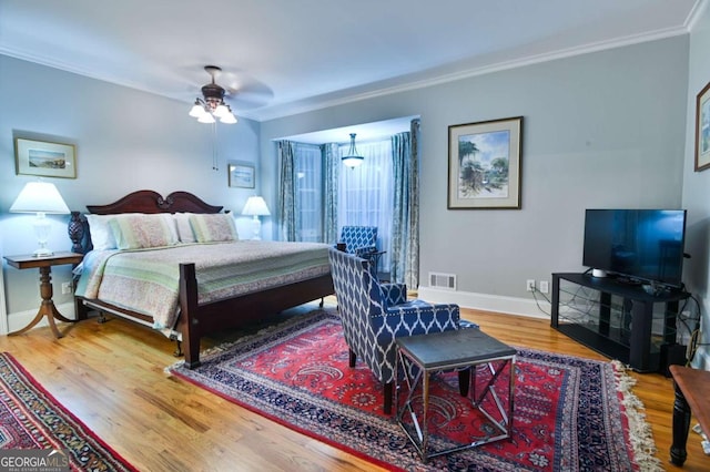 bedroom with ceiling fan, light wood-type flooring, and ornamental molding