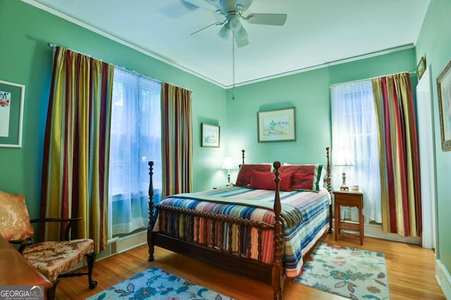 bedroom with ceiling fan, ornamental molding, and light wood-type flooring