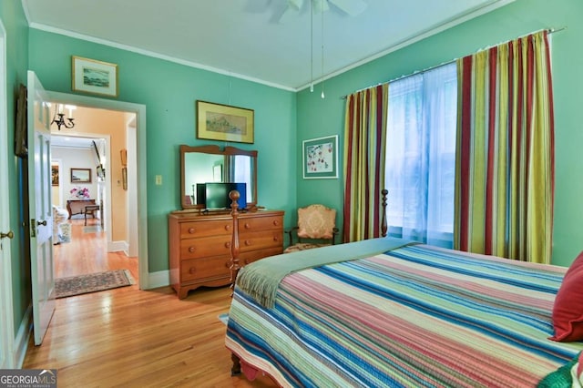 bedroom featuring ceiling fan, ornamental molding, and light wood-type flooring