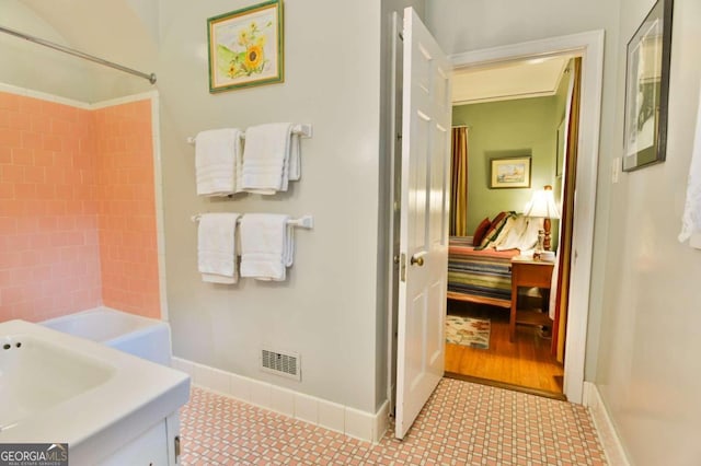 bathroom with tile patterned flooring, vanity, and shower / tub combination