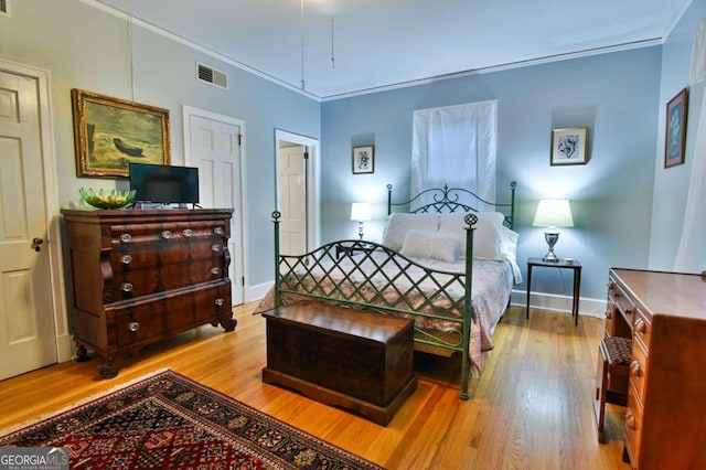 bedroom featuring light hardwood / wood-style flooring and ornamental molding