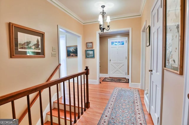 interior space featuring crown molding, a chandelier, and light wood-type flooring