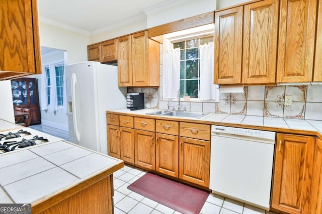 kitchen with tile counters, tasteful backsplash, ornamental molding, a sink, and white appliances