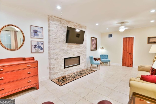 tiled living room featuring ceiling fan and a fireplace