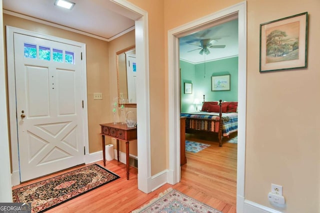 foyer entrance featuring light hardwood / wood-style floors, crown molding, and ceiling fan