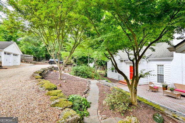 view of yard featuring an outdoor structure, a patio area, and a garage