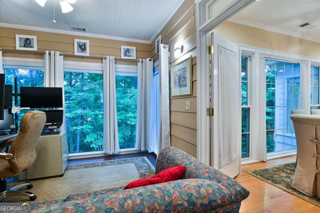 home office with plenty of natural light, ornamental molding, and light wood-type flooring