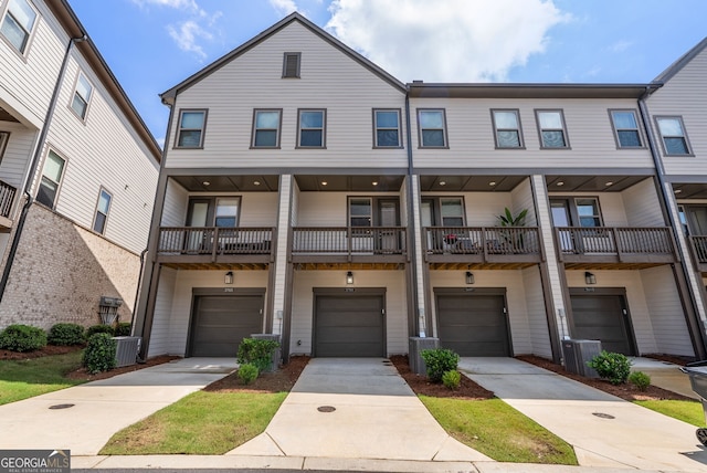 townhome / multi-family property with cooling unit, a balcony, and a garage