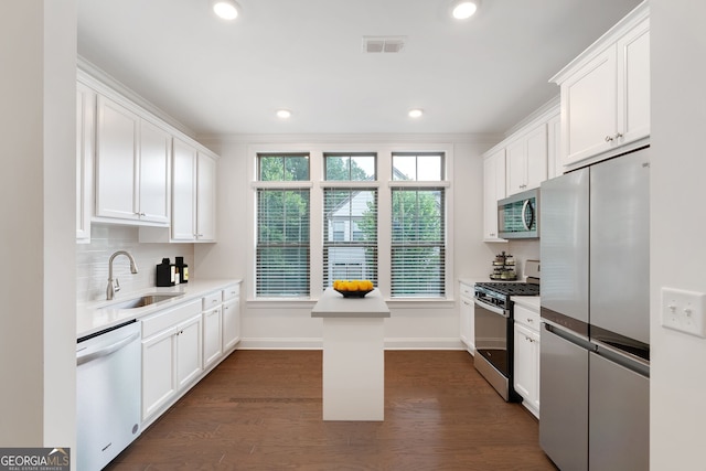 kitchen with dark wood-type flooring, a kitchen island, sink, and stainless steel appliances