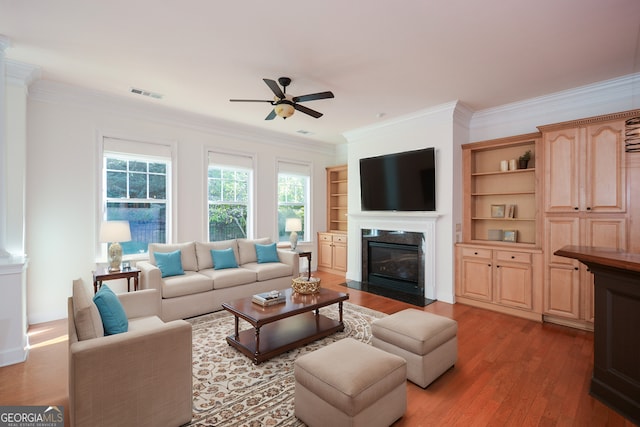 living room featuring ceiling fan, ornamental molding, and hardwood / wood-style floors