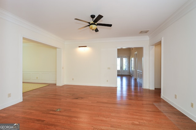 empty room with crown molding, wood-type flooring, and ceiling fan