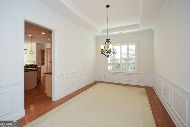 dining room with crown molding, an inviting chandelier, and hardwood / wood-style floors