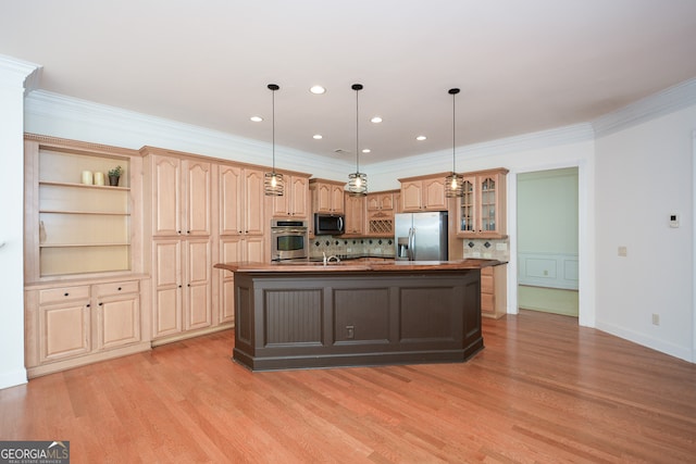 kitchen featuring appliances with stainless steel finishes, decorative light fixtures, an island with sink, and decorative backsplash