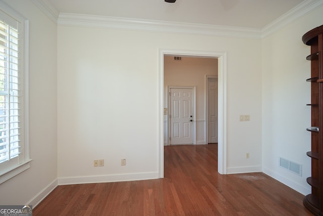 spare room featuring crown molding and dark hardwood / wood-style flooring