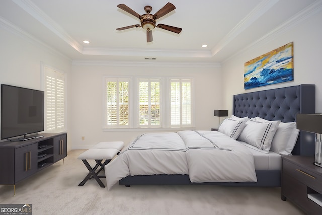 carpeted bedroom with crown molding, a tray ceiling, and ceiling fan