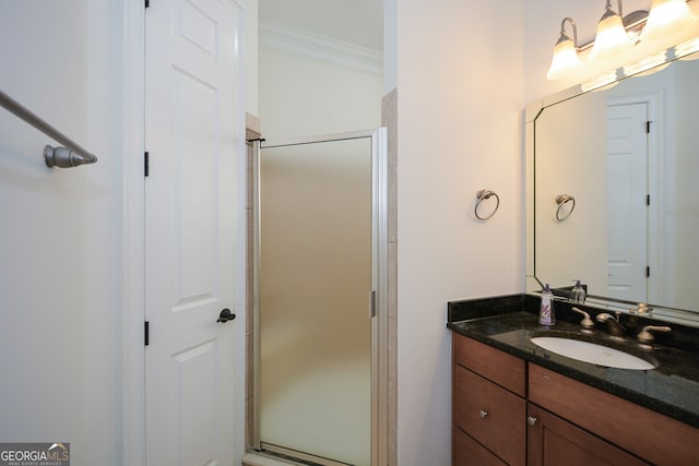 bathroom with vanity, crown molding, and a shower with shower door