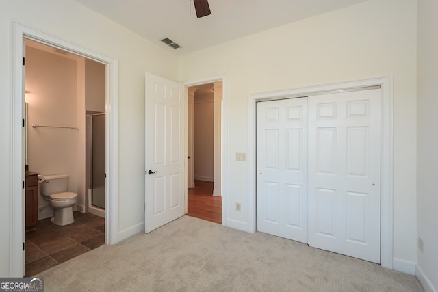 unfurnished bedroom with a closet, ceiling fan, connected bathroom, and light colored carpet