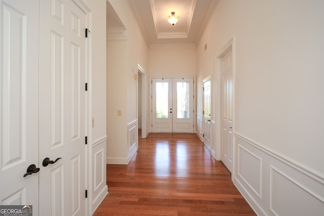 entryway with dark wood-type flooring, crown molding, and french doors