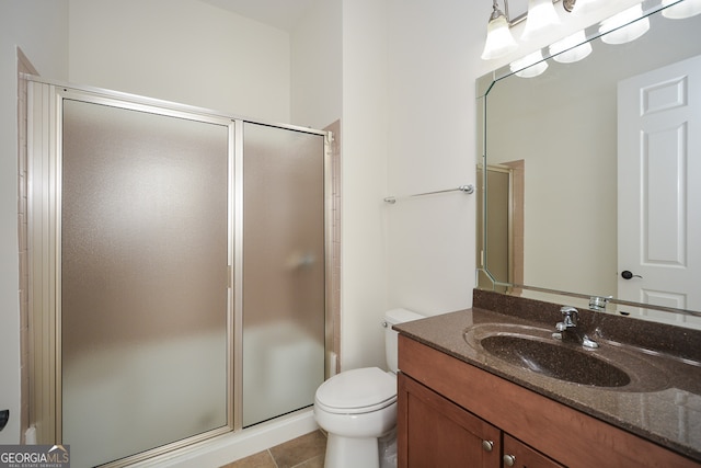 bathroom featuring vanity, tile patterned flooring, toilet, and walk in shower