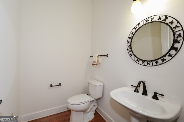 bathroom featuring sink, hardwood / wood-style floors, and toilet