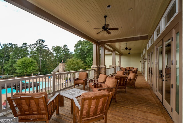 wooden terrace with ceiling fan and outdoor lounge area