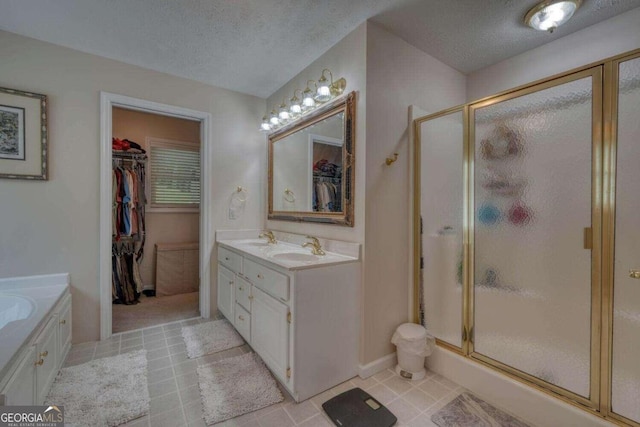 bathroom featuring vanity, independent shower and bath, and a textured ceiling