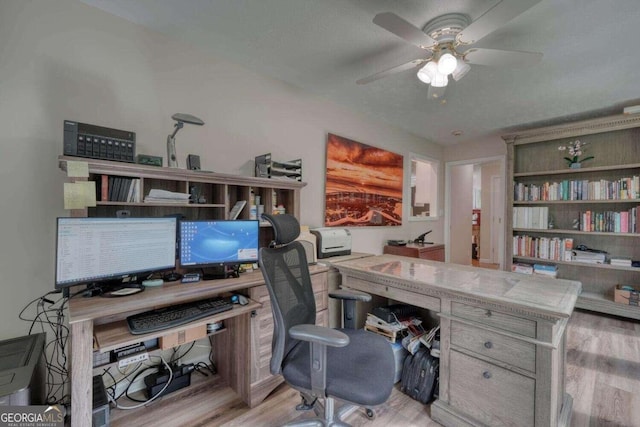 office with light wood-type flooring and ceiling fan