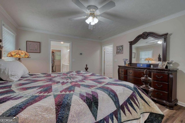 bedroom with ensuite bathroom, light hardwood / wood-style floors, ceiling fan, and crown molding