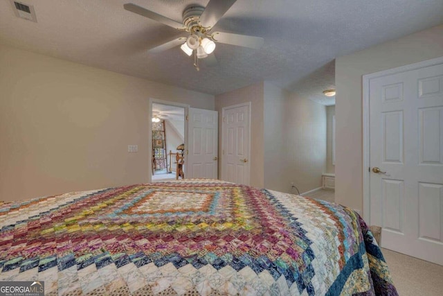 carpeted bedroom with a textured ceiling and ceiling fan