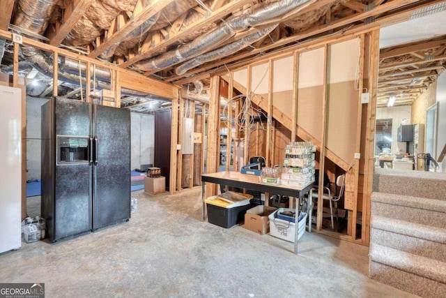 basement featuring black refrigerator with ice dispenser