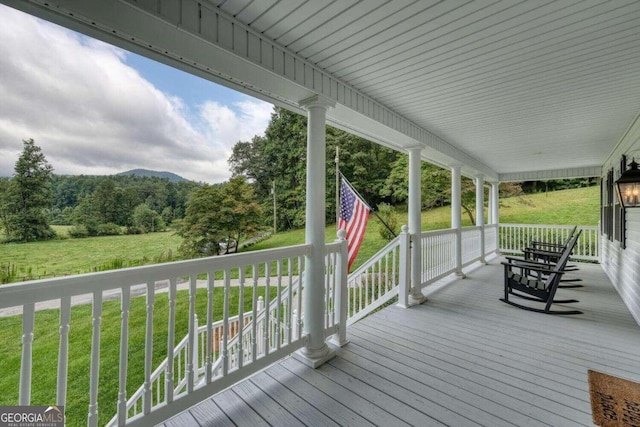 wooden deck with a yard and covered porch