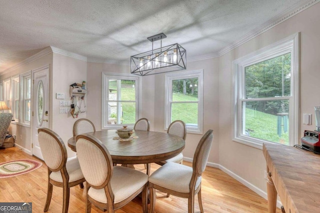 dining space with ornamental molding, light hardwood / wood-style floors, a textured ceiling, and an inviting chandelier