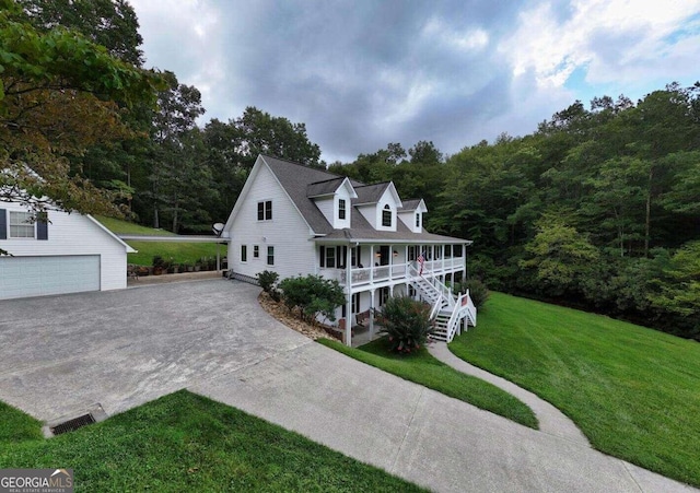 view of front of home with a front lawn, a garage, covered porch, and an outdoor structure