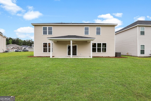 rear view of house featuring a patio, central AC, and a lawn