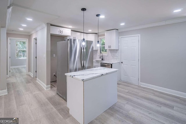 kitchen featuring sink, appliances with stainless steel finishes, light hardwood / wood-style floors, white cabinets, and decorative light fixtures