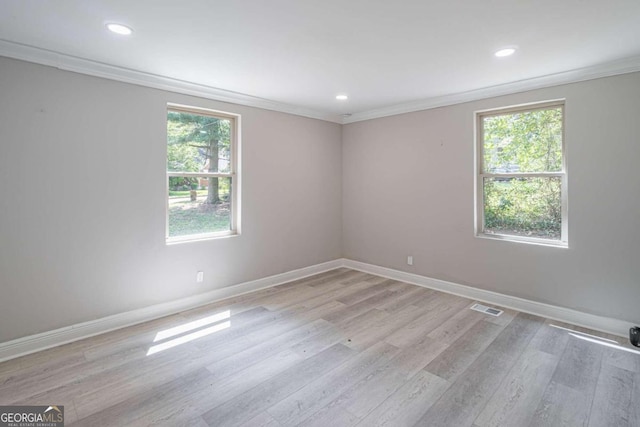 spare room featuring crown molding and light wood-type flooring