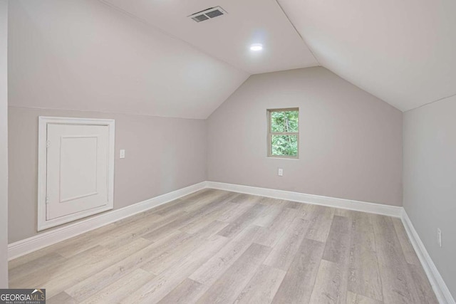 additional living space featuring lofted ceiling and light hardwood / wood-style floors