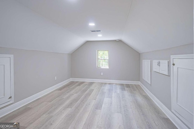 additional living space with lofted ceiling and light wood-type flooring