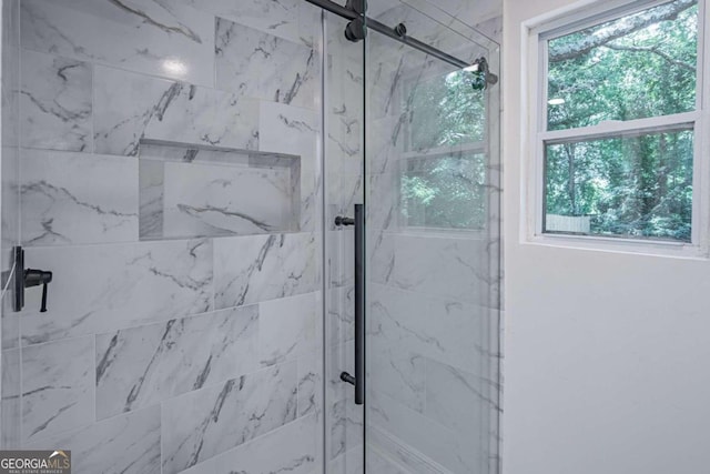 bathroom featuring a shower with door and a healthy amount of sunlight