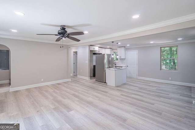 unfurnished living room featuring crown molding, ceiling fan, and light wood-type flooring