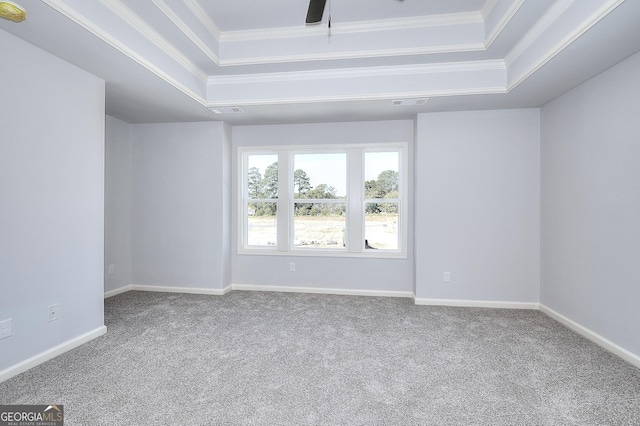 carpeted spare room with a raised ceiling and crown molding