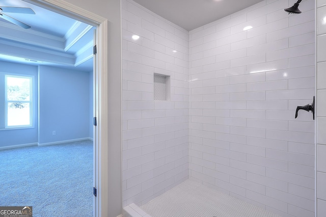 bathroom with ornamental molding and tiled shower