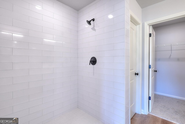 bathroom featuring hardwood / wood-style floors and tiled shower