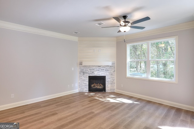 unfurnished living room featuring ceiling fan, a fireplace, ornamental molding, and wood-type flooring