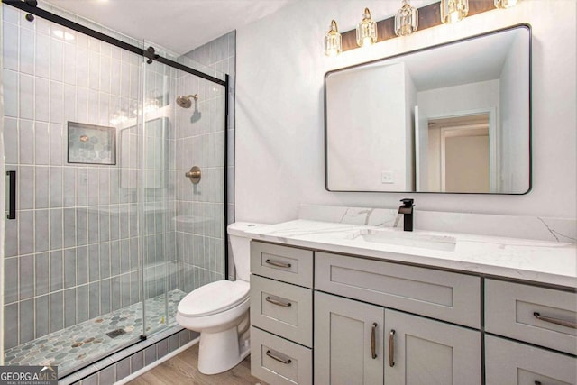 bathroom featuring wood-type flooring, toilet, vanity, and an enclosed shower