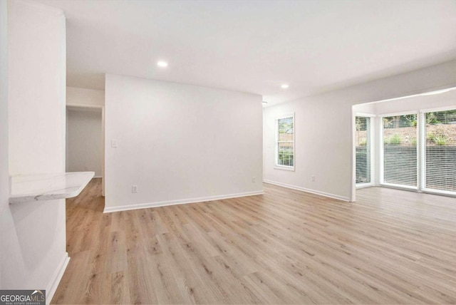 unfurnished living room featuring light hardwood / wood-style floors and a wealth of natural light