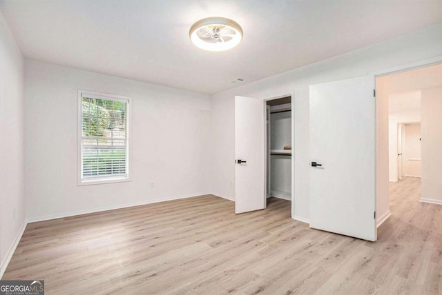 unfurnished bedroom featuring light hardwood / wood-style floors and a closet